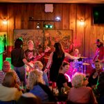 Live band playing on O'Michael's stage with dancers and diners.