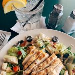 O'Michael's Pub & Grill chicken salad with olives on plate with glass of lemon water.