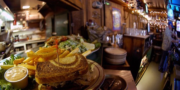 O'Michael's Pub & Grill club sandwich with fries on plate.